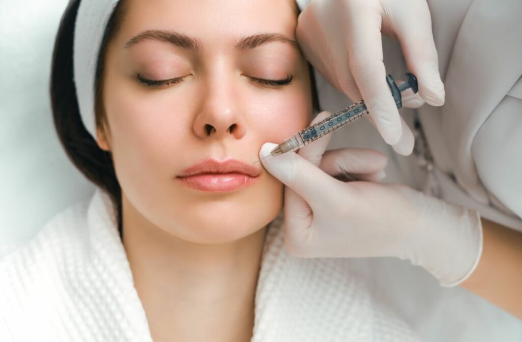  A woman relaxes while receiving a lip filler injection in a clinic.