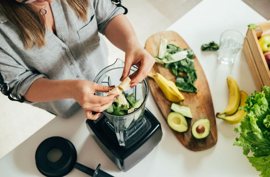 A patient prepares a soft, light-colored smoothie after their teeth whitening treatment.